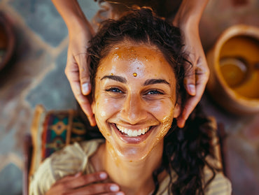 An american woman smiling while getting an ayurvedic oil massage.