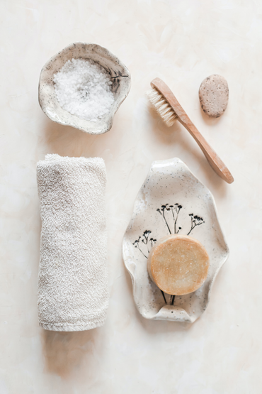 ayurvedic soap, brush and towel placed in a bathroom counter top.