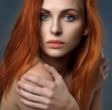 a woman with red hair and clear skin.