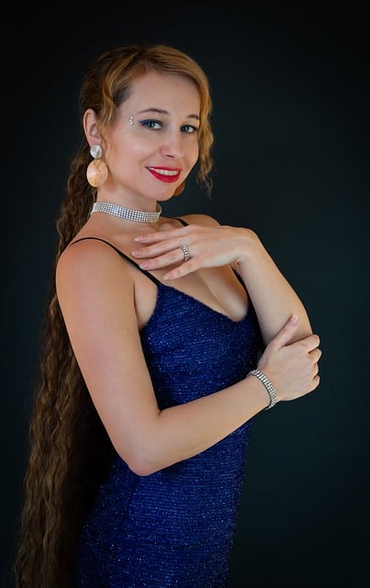a woman with long hair wearing an indigo colored dress.